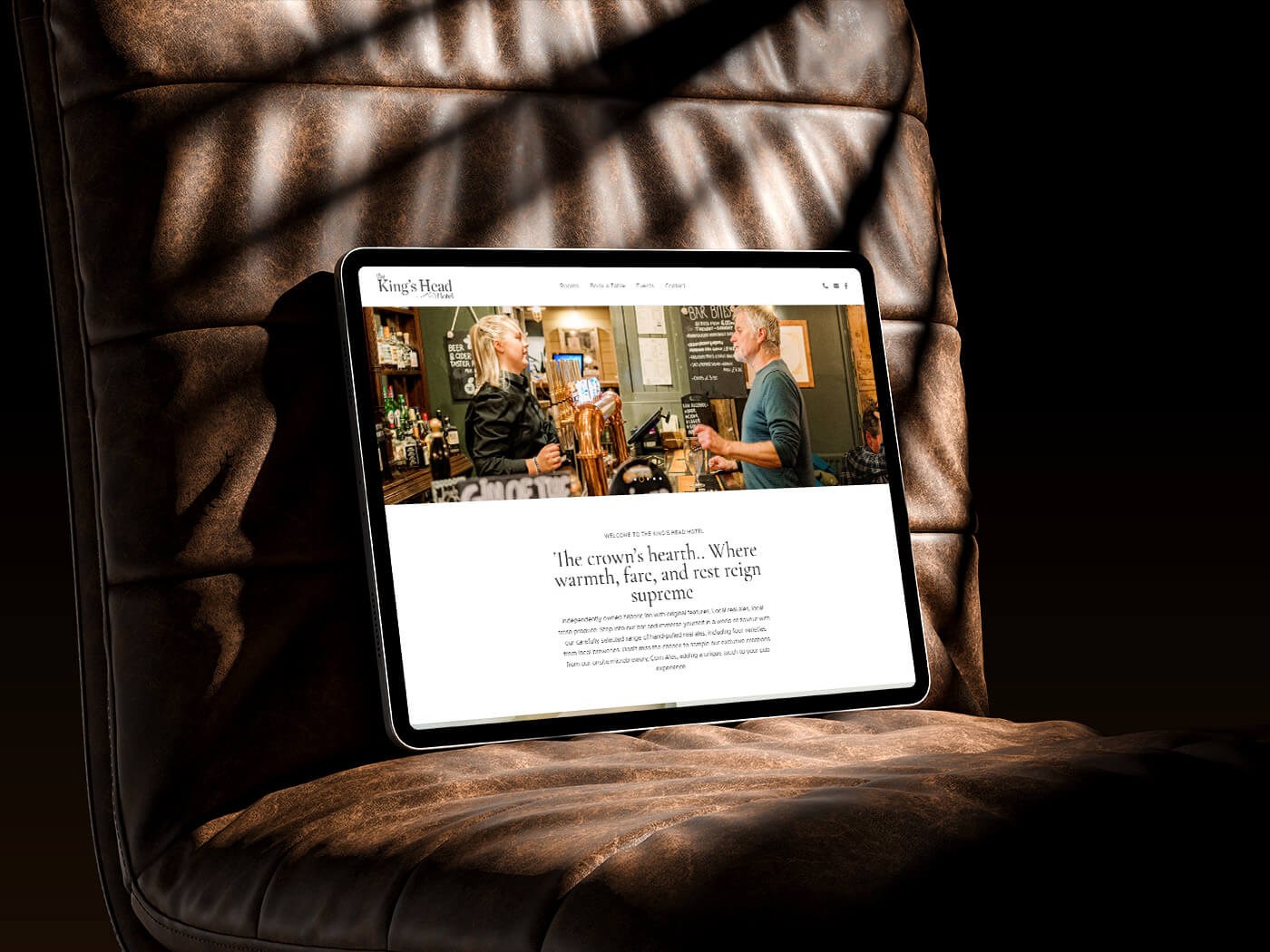 tablet showing a responsive website, propped up on a leather office chair